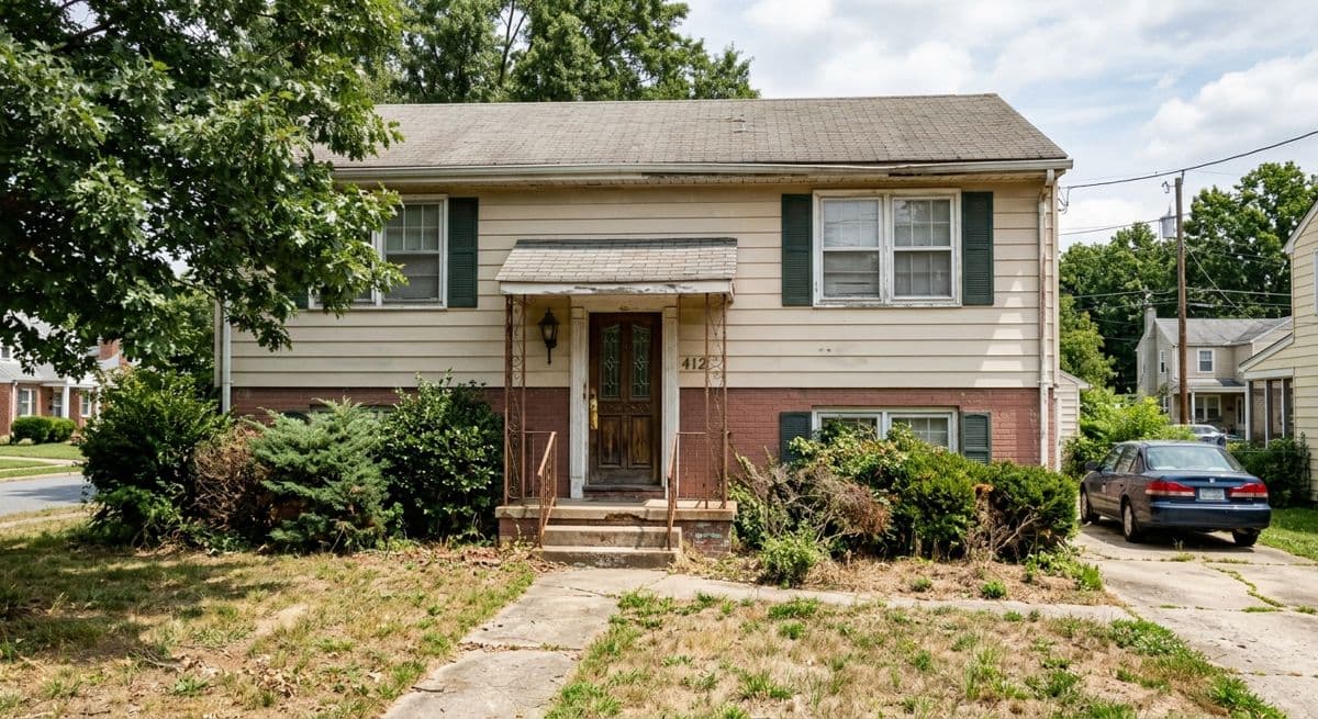Before: dated two-storey house with beige siding, brick base and overgrown front yard